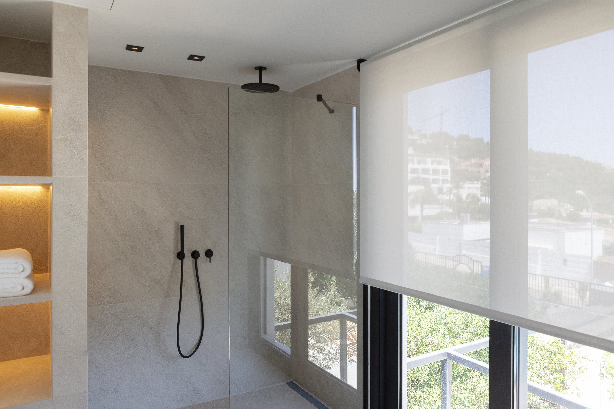 Bad mit lichtdurchlässigem Rollo am Fenster neben der Dusche