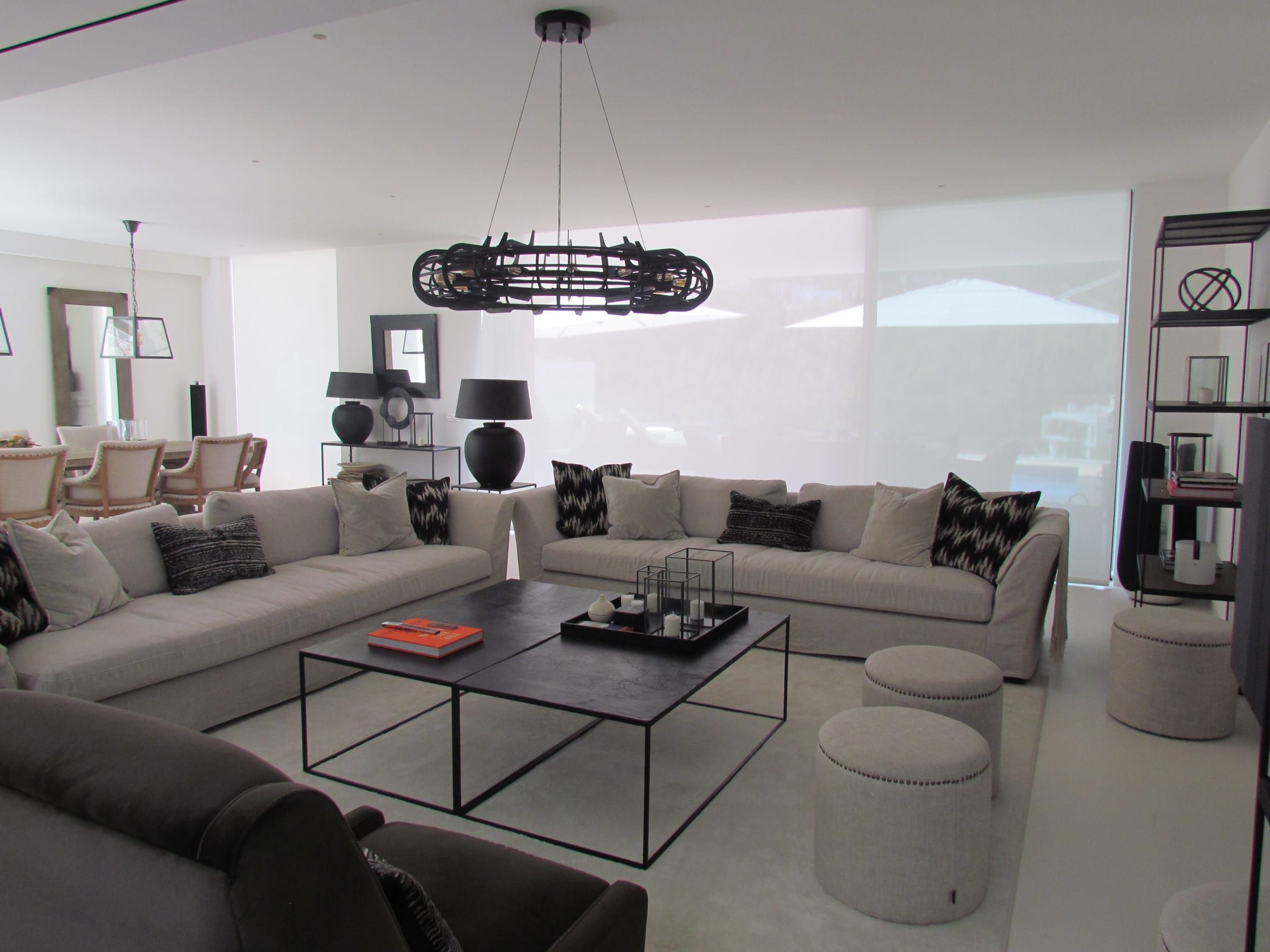 Living room with white roller blinds lowered across the windows