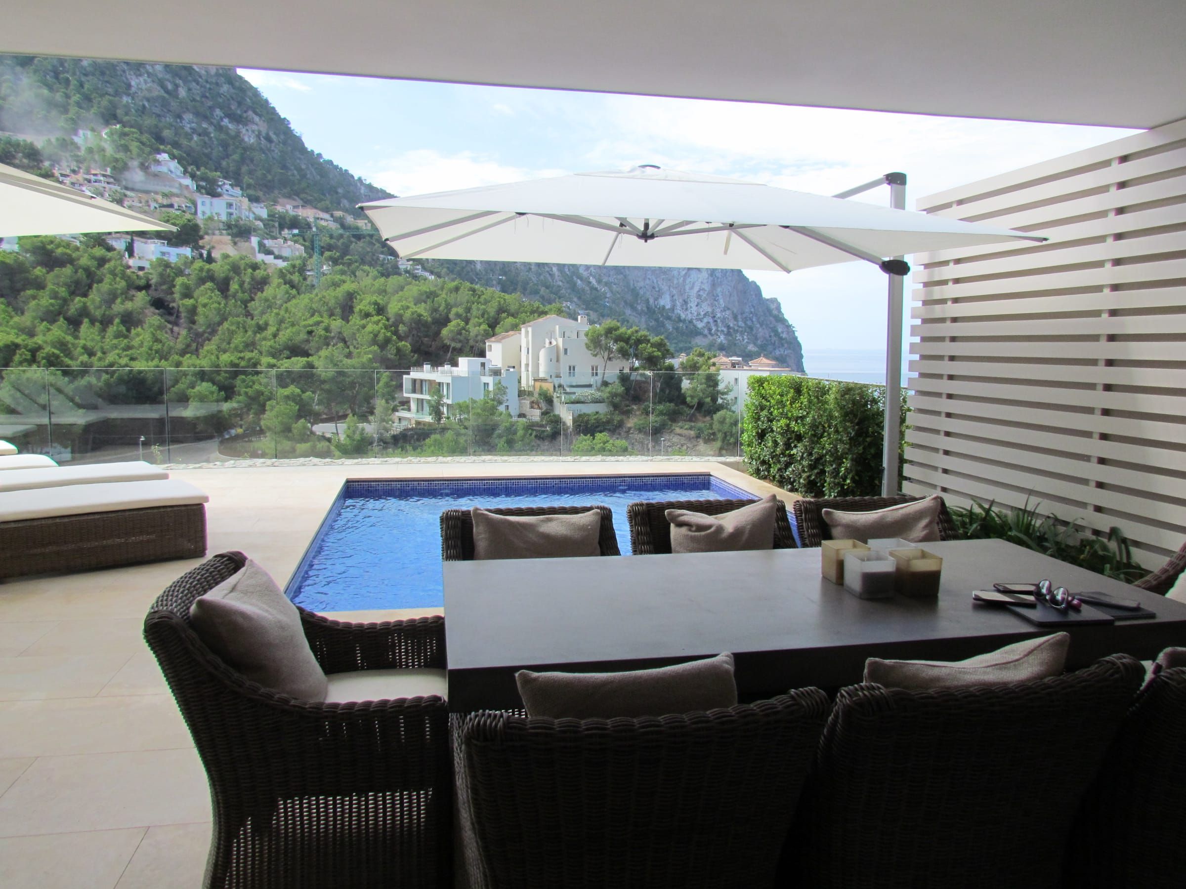 Side-arm parasol beside the pool and the outdoor dining table