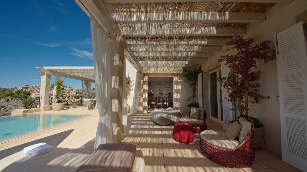 Veranda mit Lounge-Bereich und weißen Vorhängen entlang der Pergola, neben dem Pool