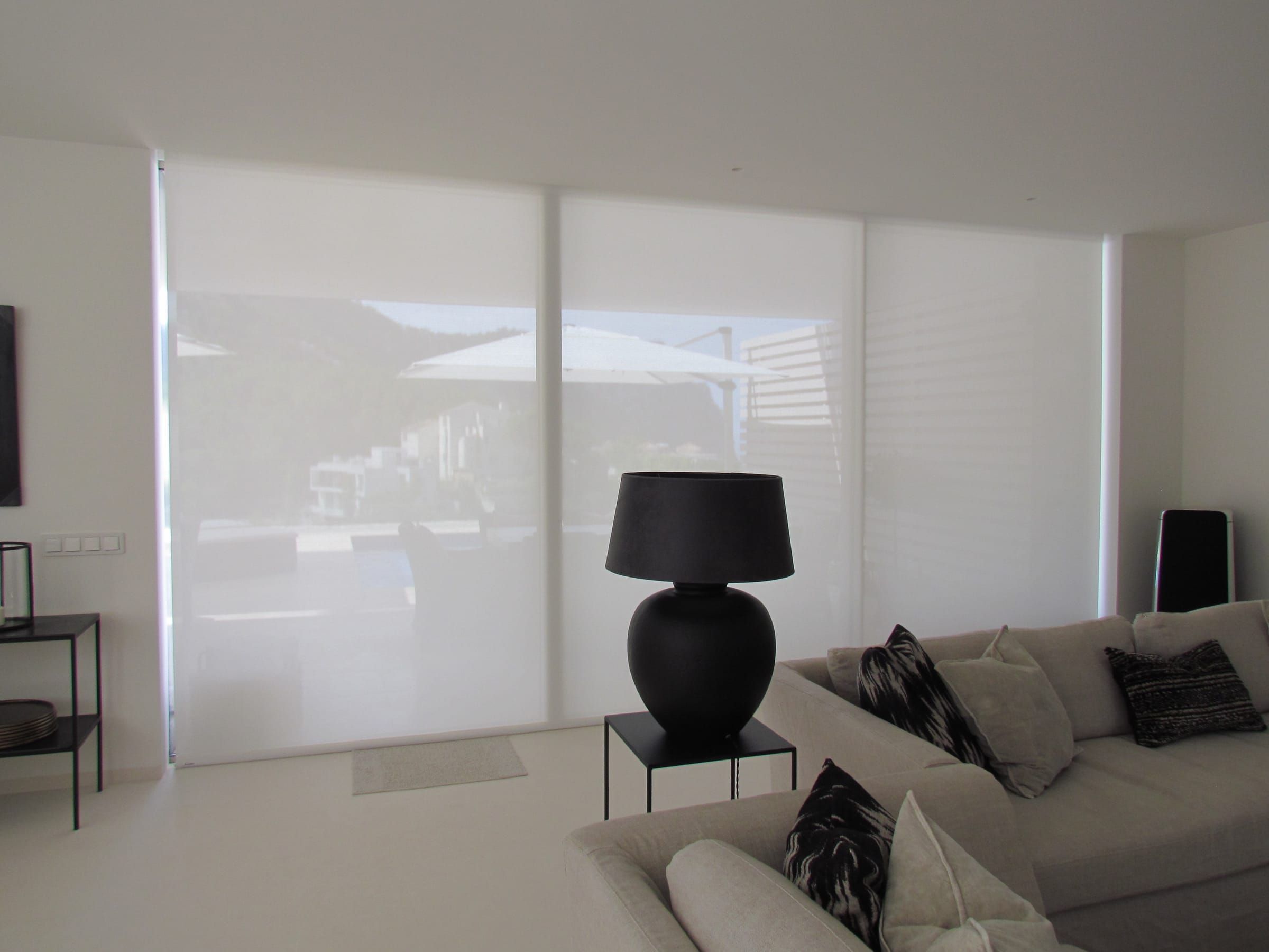 Three roller blinds covering the living room window wall