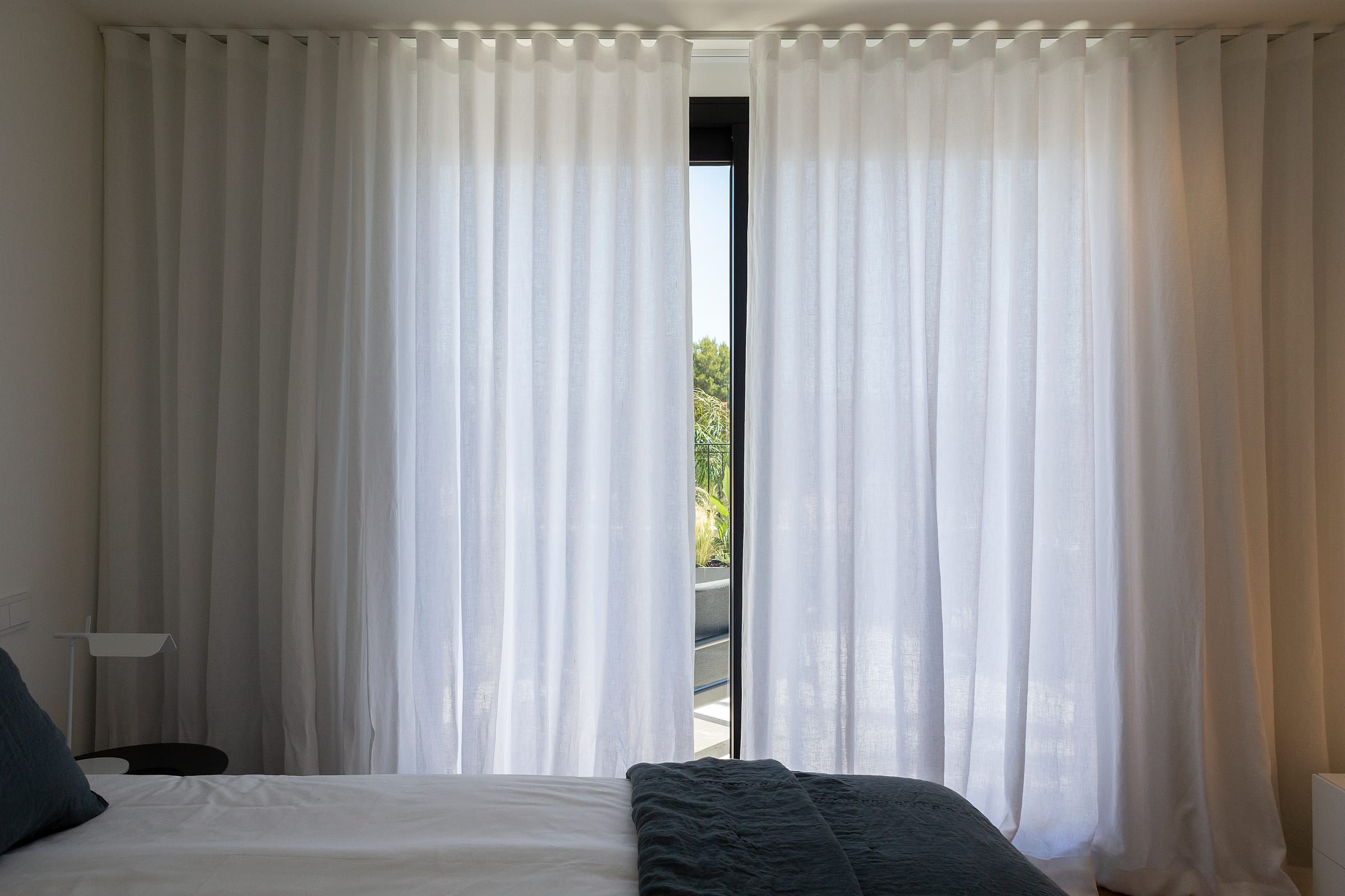 Geschlossene Wellenvorhänge im Schlafzimmer mit gefiltertem Licht