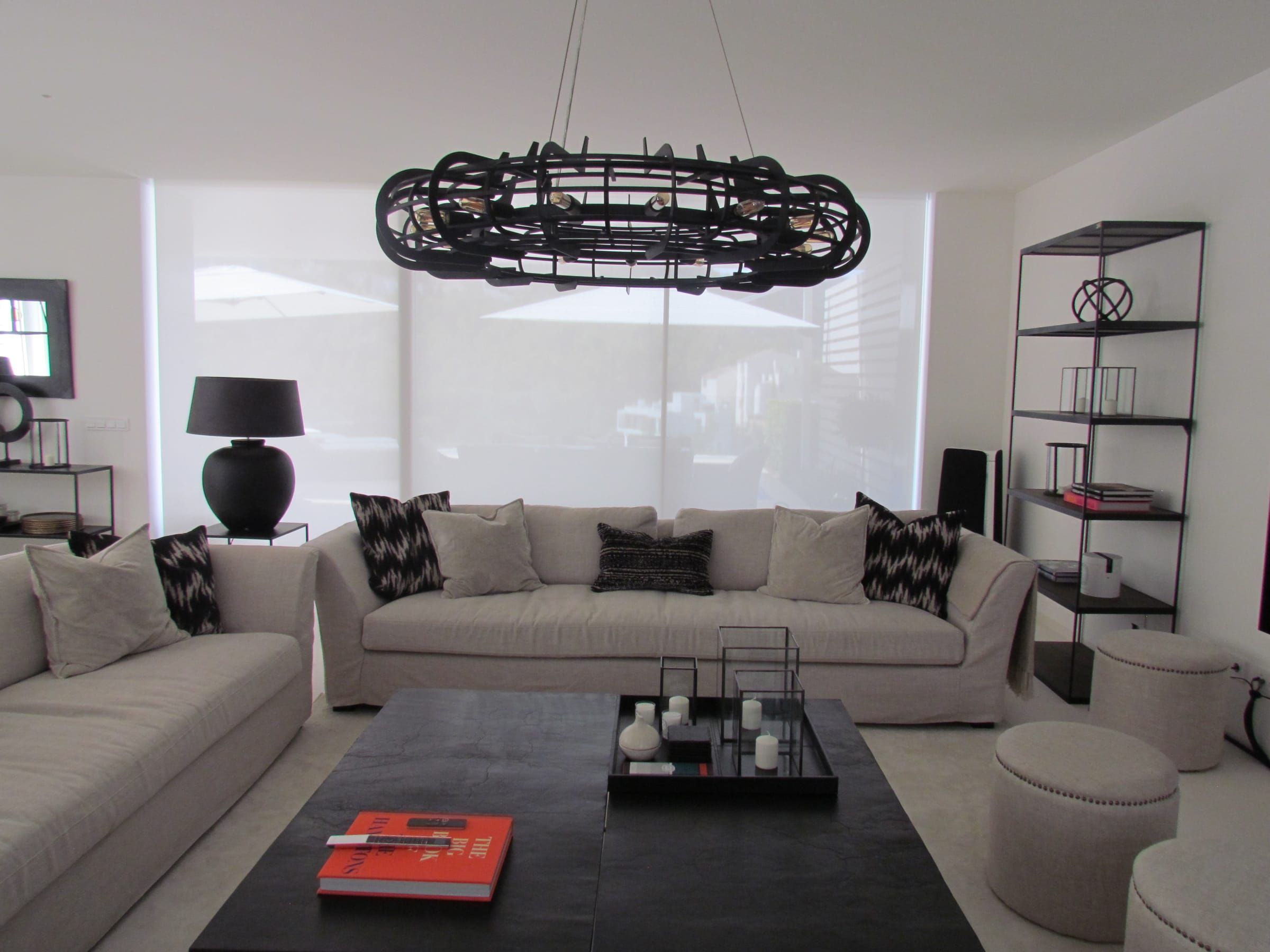 Living room with pale sofas and roller blinds lowered behind