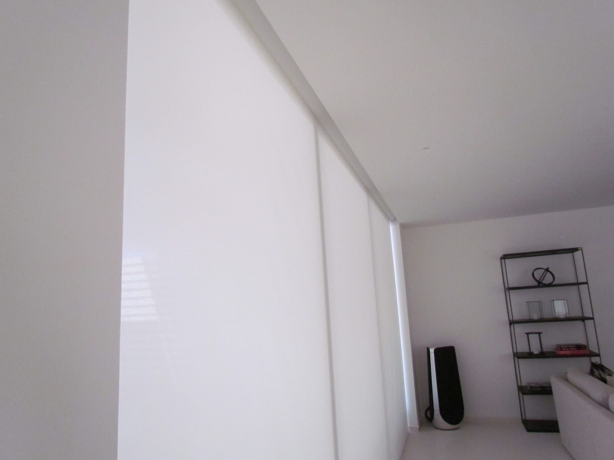 Roller blind retracting into a recess in the ceiling