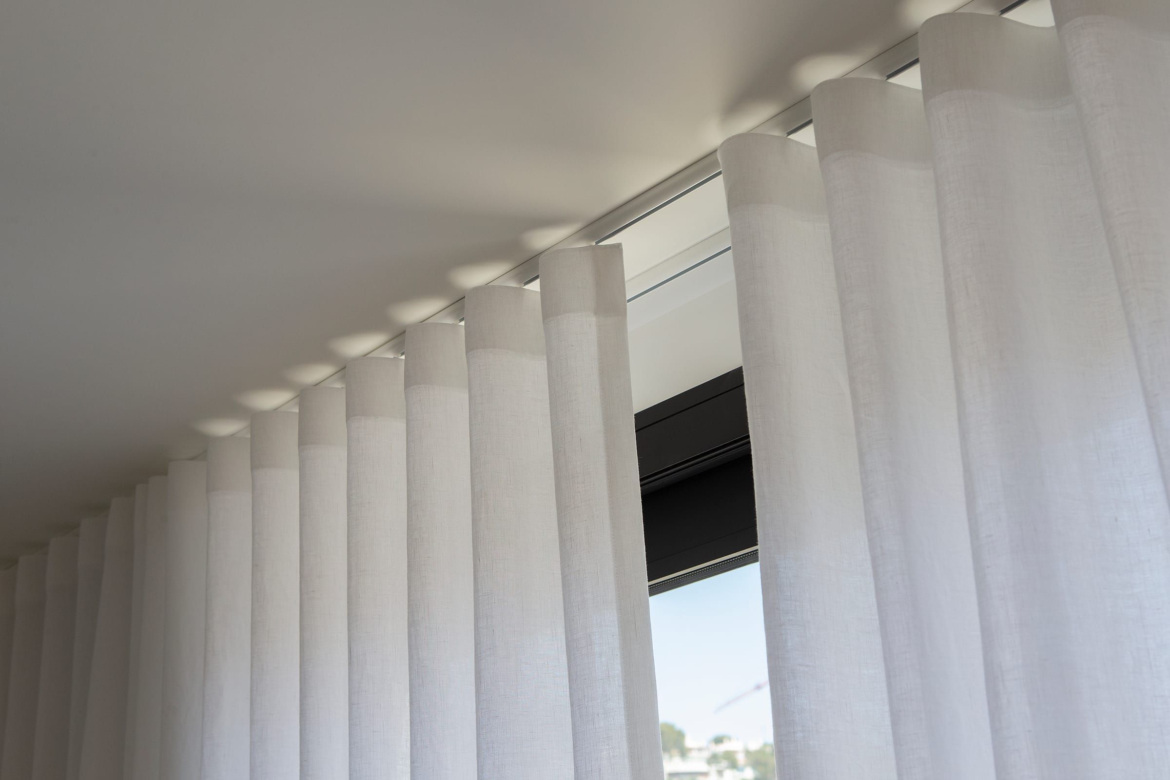 Detail der gleichmäßigen Wellenfalten am Fenster