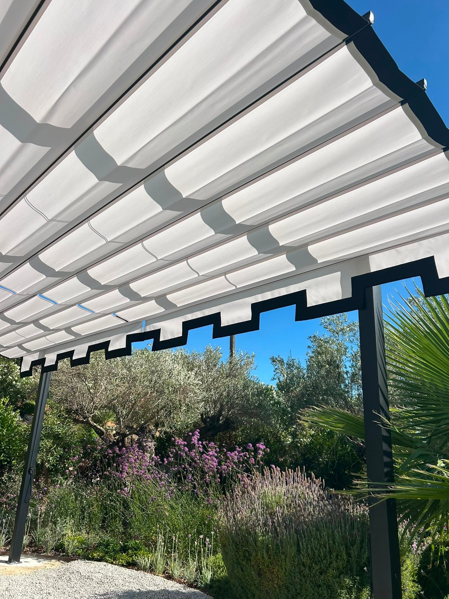 Tuch der Faltmarkise mit dem mediterranen Garten im Hintergrund