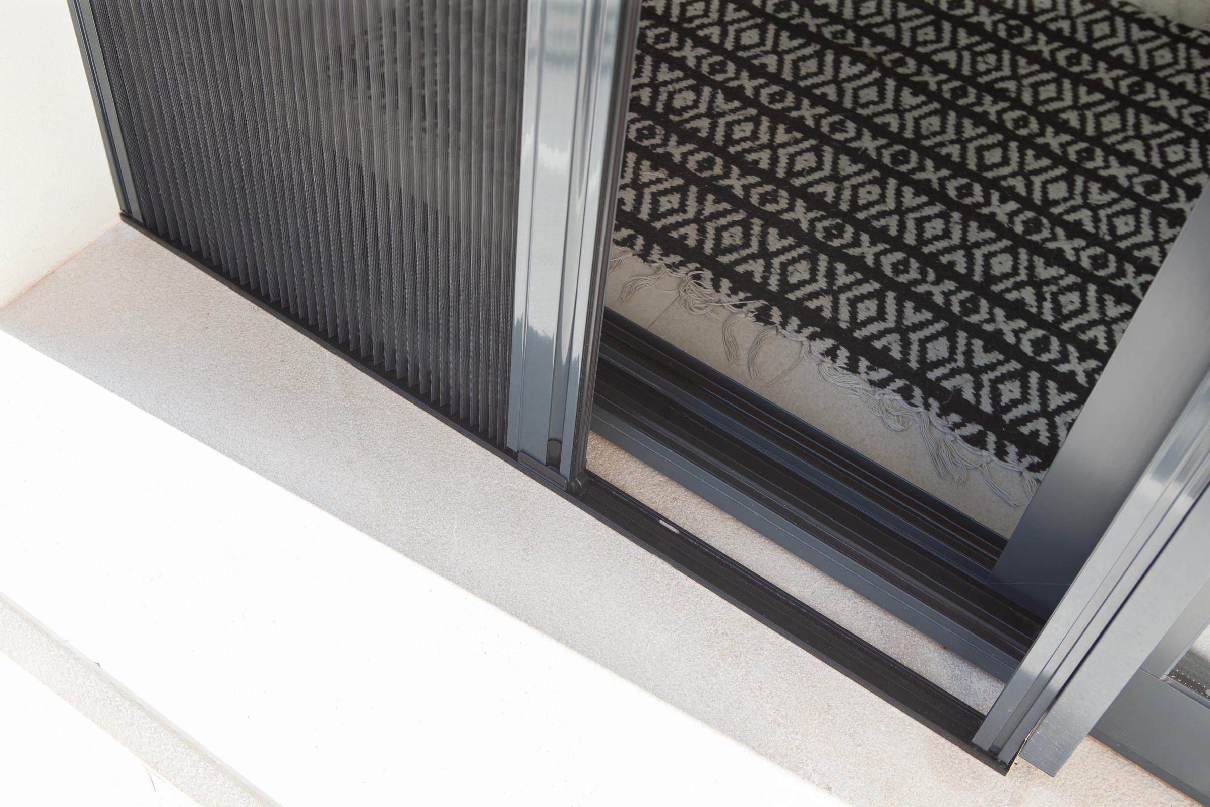 Detail of the pleated insect screen in the bottom track of a sliding door