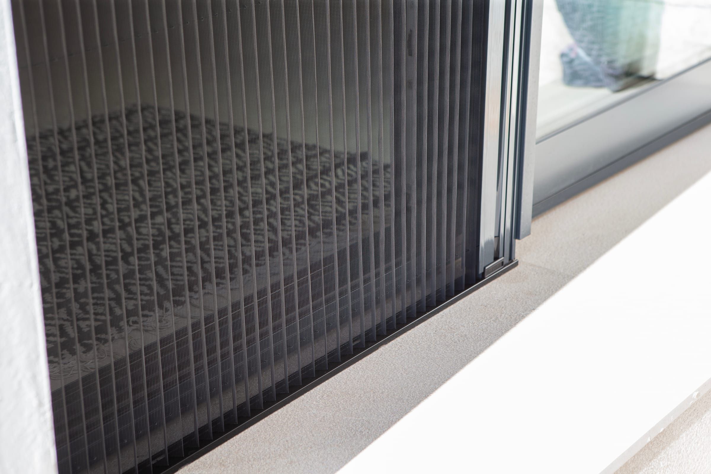 Pleated insect screen drawn across a sliding door opening