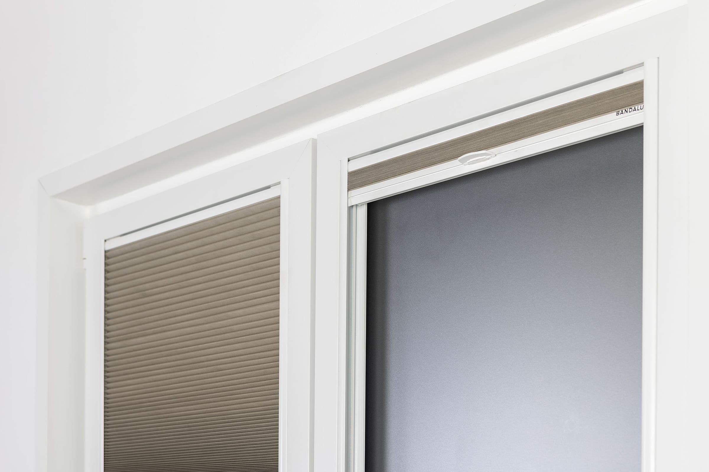 Detalle de estores plisados Fit Pleat adheridos al marco de una ventana